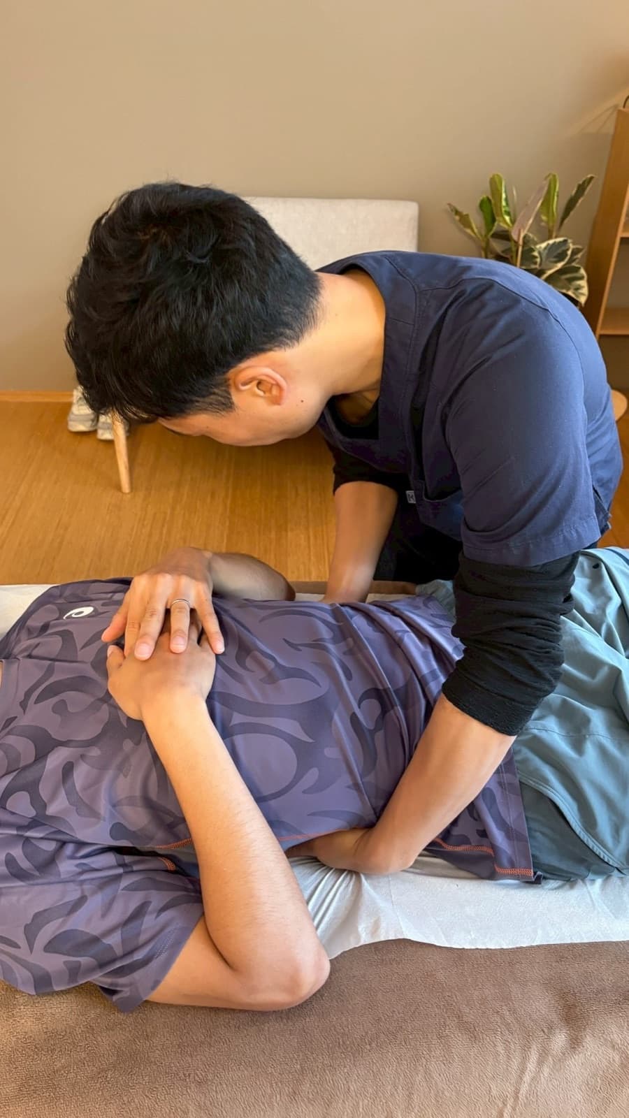 Soichiro Funo treating deep-tissue triggers along the spine at Alter Physio Amsterdam
